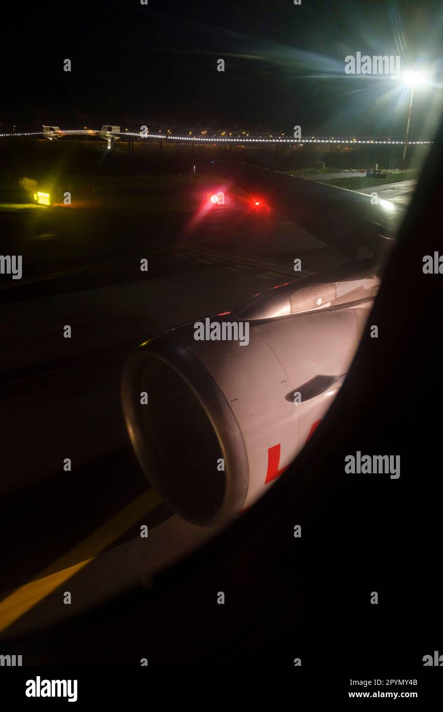 Guardando fuori dalla finestra di un aeroplano di notte mentre si prepara per il decollo dall'aeroporto di Bologna in Italia. Foto Stock