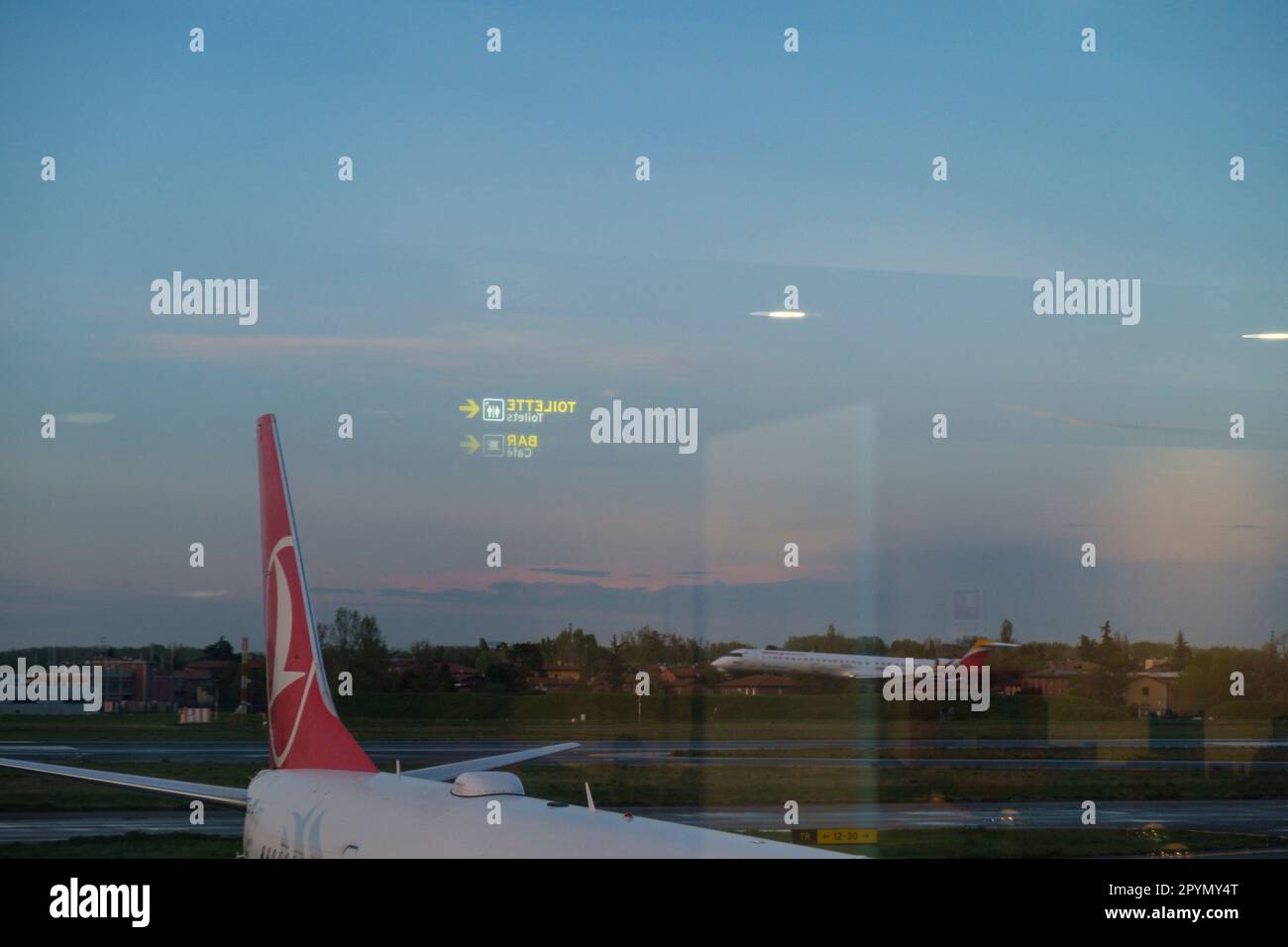 Vista da una sala partenze dell'aeroporto con aereo sul grembiule. Foto Stock