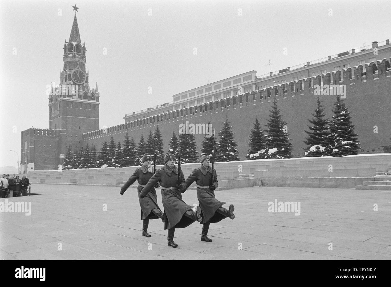 1985: Poco prima delle 12, secondo l'orologio della Torre Spassky del Cremlino, una folla guarda il cambio della guardia d'onore al mausoleo di Lenin appena fuori dalle mura del Cremlino in Piazza Rossa, Mosca, 1985. Il presidente Boris Eltsin ha rimosso la guardia d'onore nell'ottobre 1993. Foto Stock