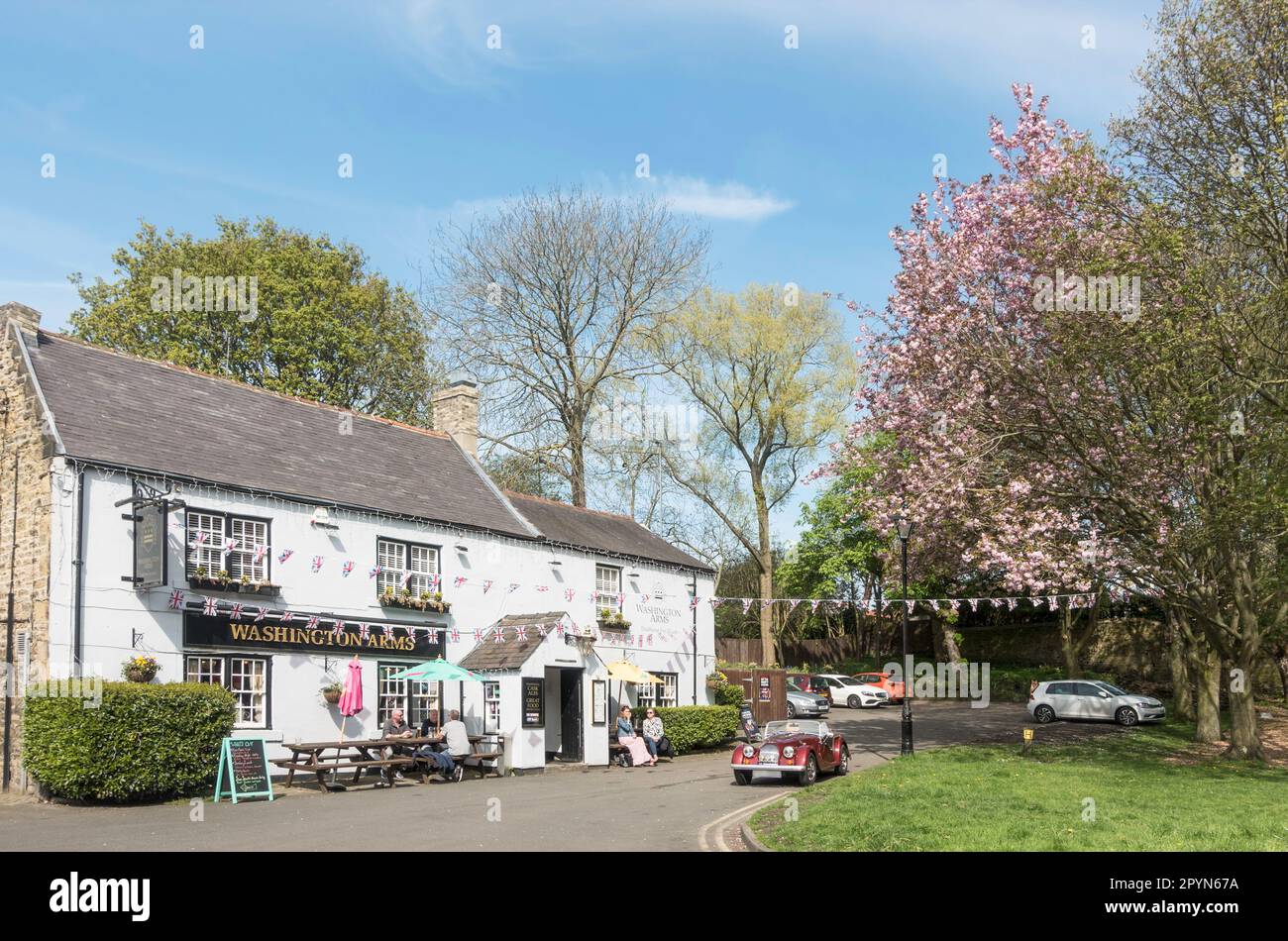 Persone sedute fuori dal pub Washington Arms a Washington Village, Inghilterra nord-orientale, Regno Unito Foto Stock