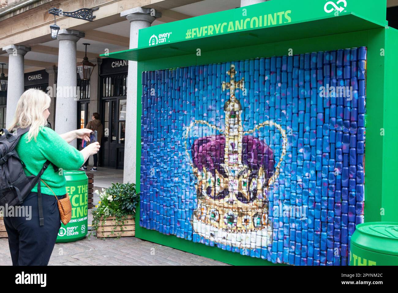 Londra, Regno Unito. 4th maggio, 2023. Il bunting di Union Jack rende il mercato di Covent Garden ancora più fotogenico per i turisti in vista dell'incoronazione di Re Carlo III sabato 6 maggio. Qui una parete di lattine è stata verniciata a spruzzo con un'immagine gigante della corona di Sant'Edoardo che viene indossata solo per le incoronazioni. Credit: Anna Watson/Alamy Live News Foto Stock