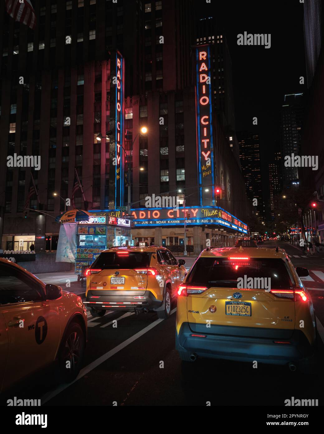 Taxi gialli e radio City Music Hall segno al neon di notte, Manhattan, New York Foto Stock