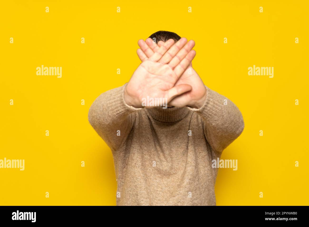 Uomo ispanico in piedi su sfondo giallo rifiuto espressione di attraversare le sue braccia e palme facendo un segno negativo. Foto Stock