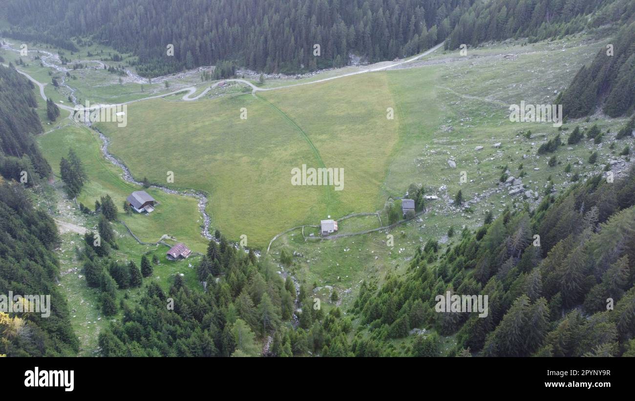 Ein schmals tal, Mitten in den Bergen, mit einzelnen kleinen Almhütten Foto Stock