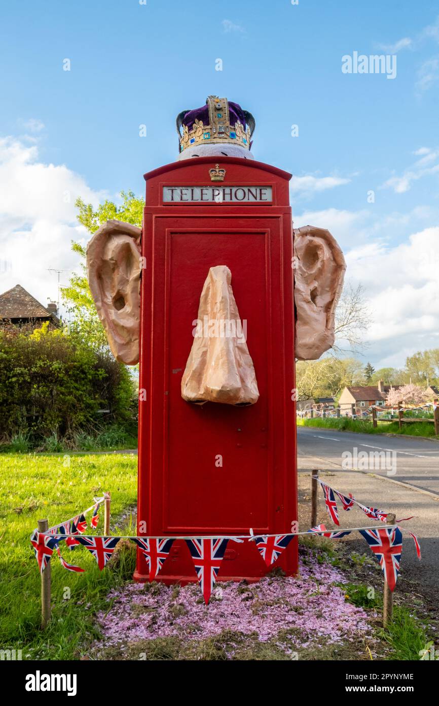 Maggio 4th 2023. Un divertente phonebox decorato un paio di giorni prima dell'incoronazione del re Carlo III e della regina Camilla. Le decorazioni irriverenti nel villaggio Surrey di Compton, Inghilterra, Regno Unito, includono grandi orecchie sporgenti e naso con una corona. Foto Stock