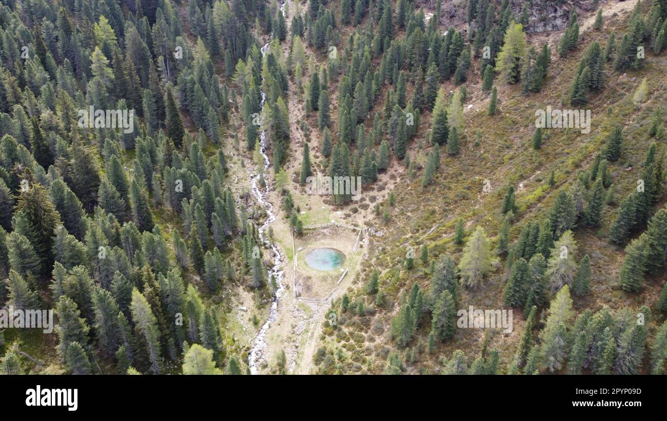 Kleiner Löschteich, mit türkiesblauem Wasser, inmitten einer malerischen Bergwelt in Südtirol- Luftbildaufnahme Foto Stock