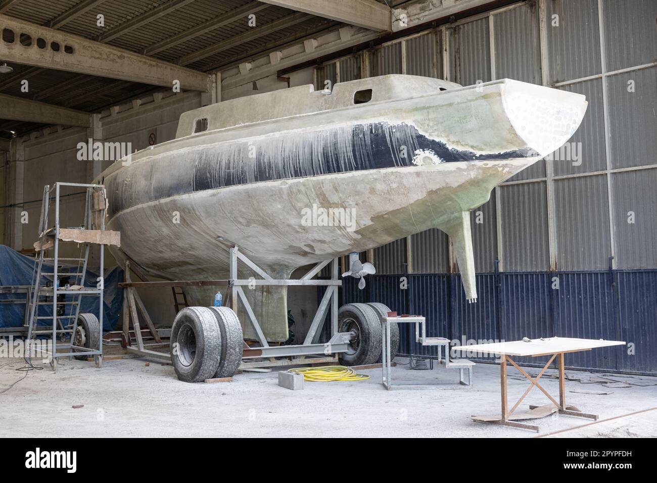 Lo yacht in vetroresina viene riparato in un cantiere. Restauro barche Foto Stock