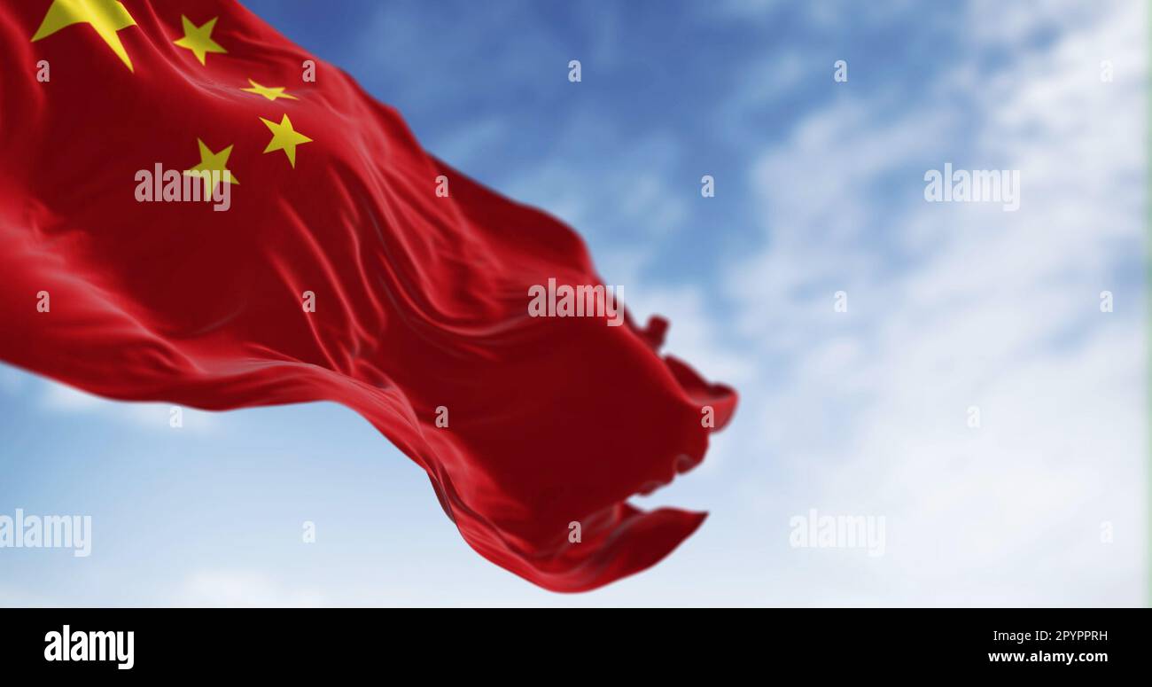 Bandiera nazionale della Cina che sventola in una giornata di sole. Sfondo rosso, cinque stelle gialle. La stella più grande simboleggia la guida del Par comunista cinese Foto Stock