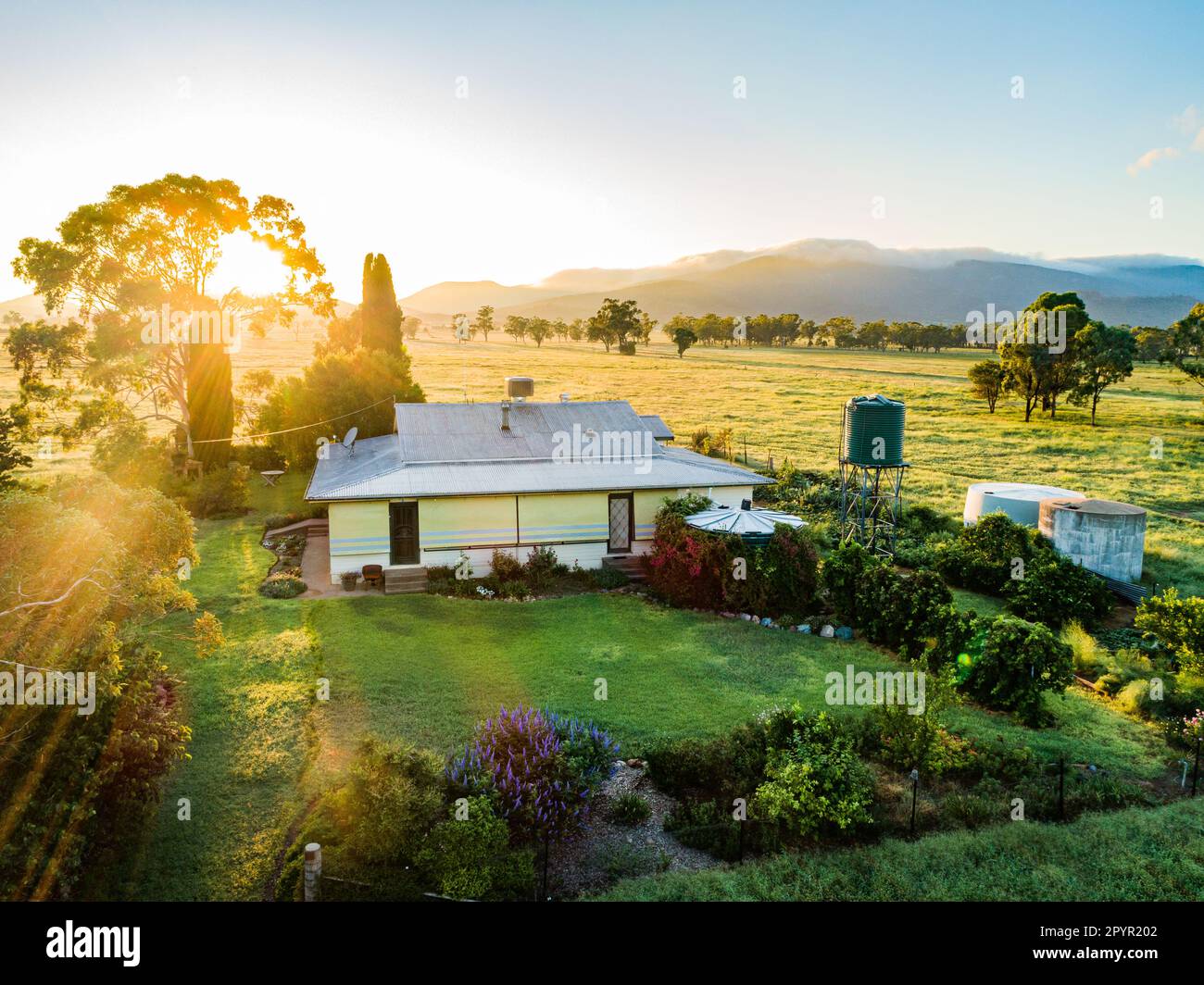Alba dietro casa colonica fattoria e cortile con serbatoio d'acqua su proprietà rurale Foto Stock