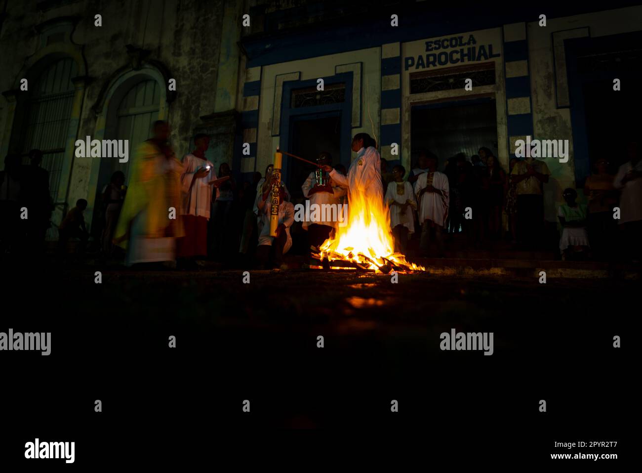 Valenca, Bahia, Brasile - 08 aprile 2023: Si vede un sacerdote che celebra la messa notturna intorno al falò di Santa il sabato sera di Hallelujah. Settimana Santa i Foto Stock
