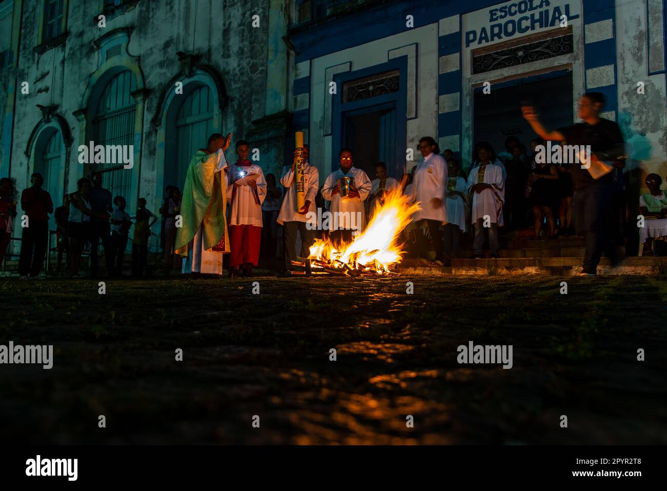 Valenca, Bahia, Brasile - 08 aprile 2023: Il sacerdote cattolico festeggia la messa notturna intorno al falò sacro su hallelujah sabato sera. Settimana Santa in Foto Stock