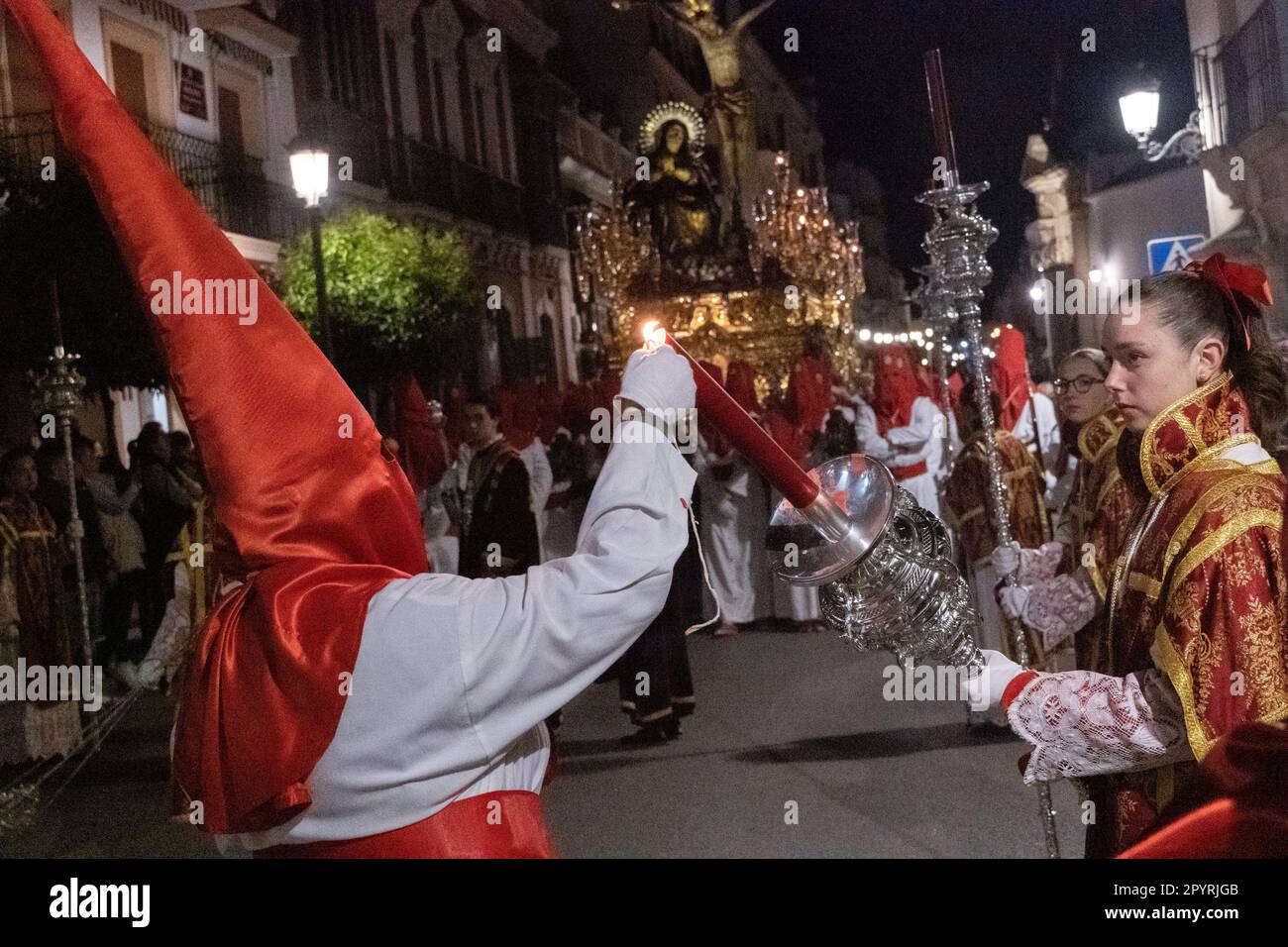 Le cofradias che indossano cappe a forma di cono rosso illuminano le loro candele durante la processione silenziosa di mezzanotte che segna il Venerdì Santo alla settimana Santa o Semana Santa, 6 aprile 2023 a Ronda, Spagna. Ronda, insediata per la prima volta nel 6th° secolo a.C., ha tenuto le processioni della settimana Santa per oltre 500 anni. Foto Stock