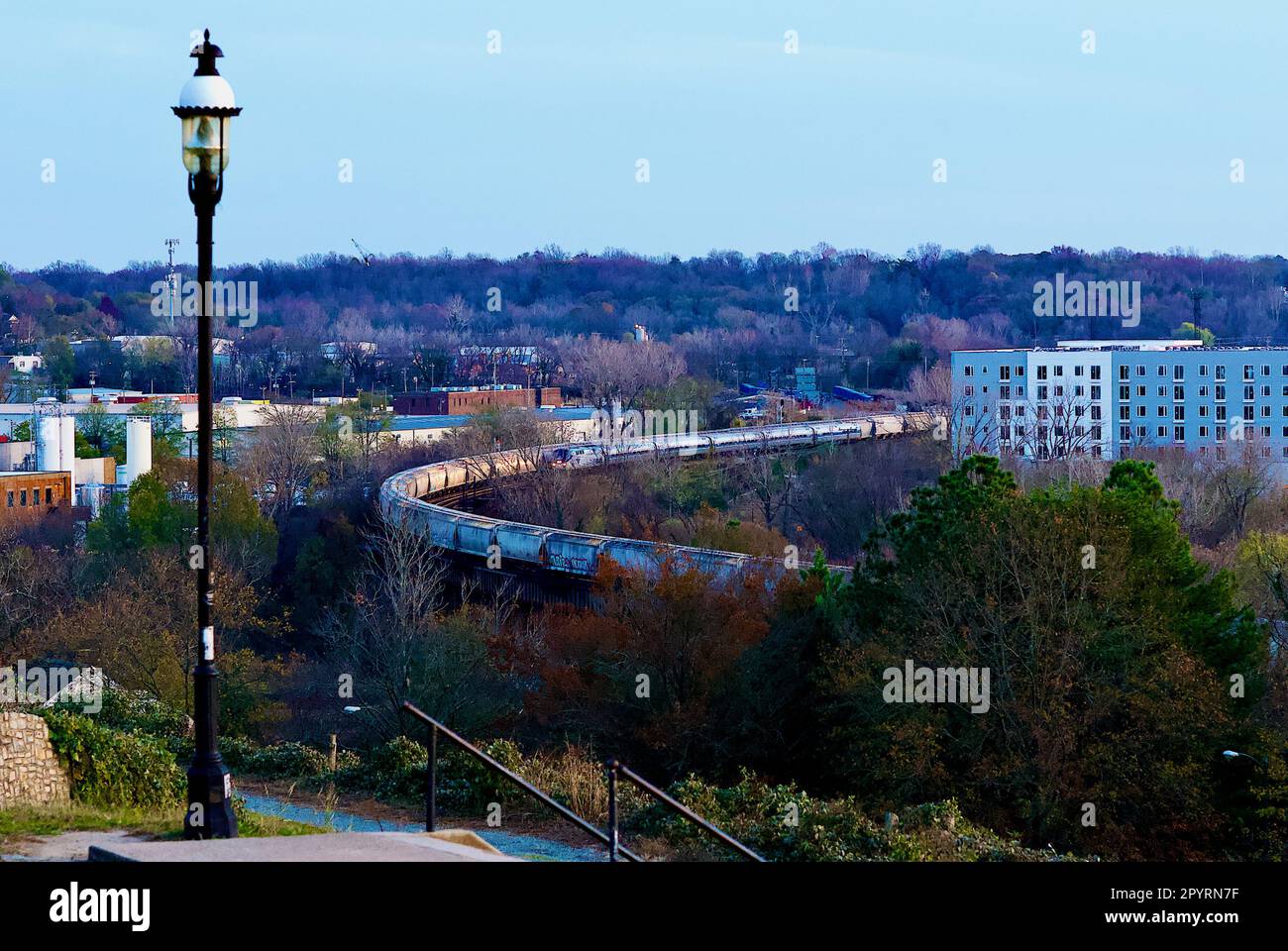 Il treno regionale per passeggeri della Amtrak passa per un treno merci in direzione est lungo il fiume James, vicino al centro di Richmond, Virginia, Stati Uniti. Foto Stock