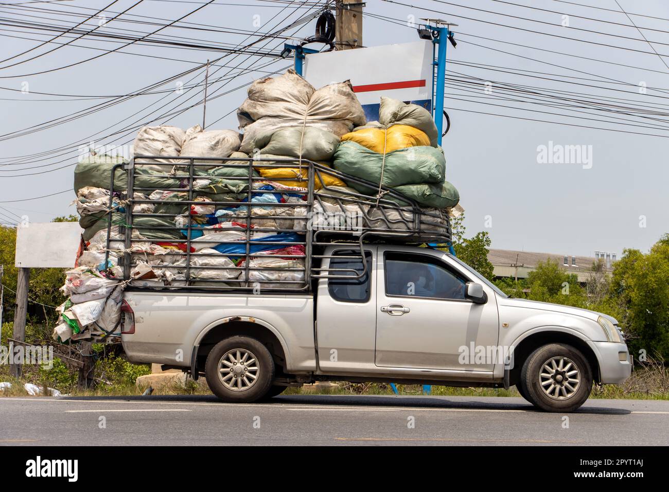 Un pick up auto caricato con molti sacchi giro su una strada, Thailandia Foto Stock