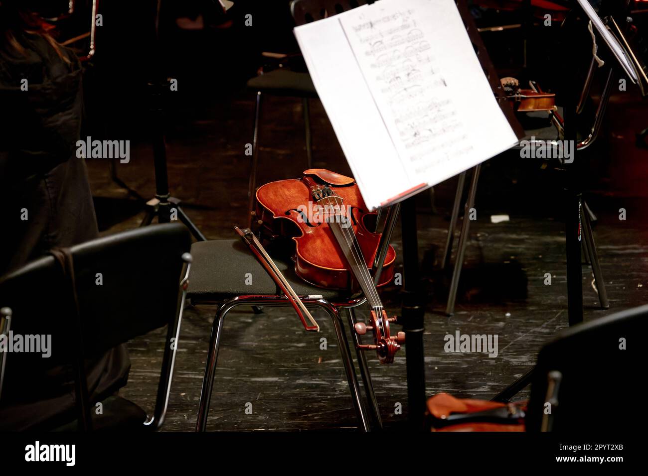 L'immagine di un violino con corde di legno si trova su una sedia Foto Stock