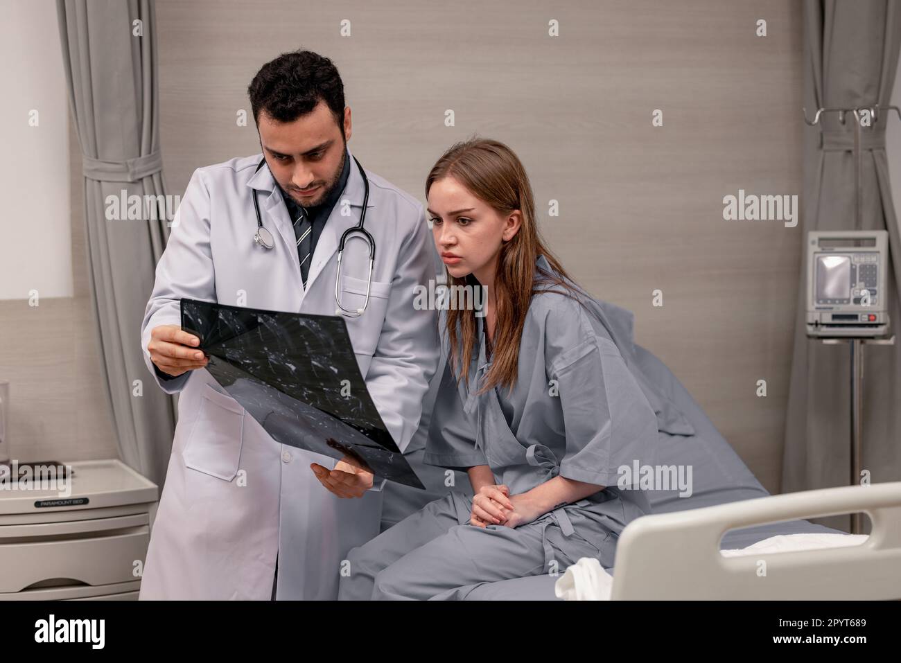 Il medico e il radiologo analizzano le immagini mediche, inclusa la pellicola per RM, per identificare le condizioni del paziente al fine di sviluppare piani di trattamento e farmaci futuri Foto Stock