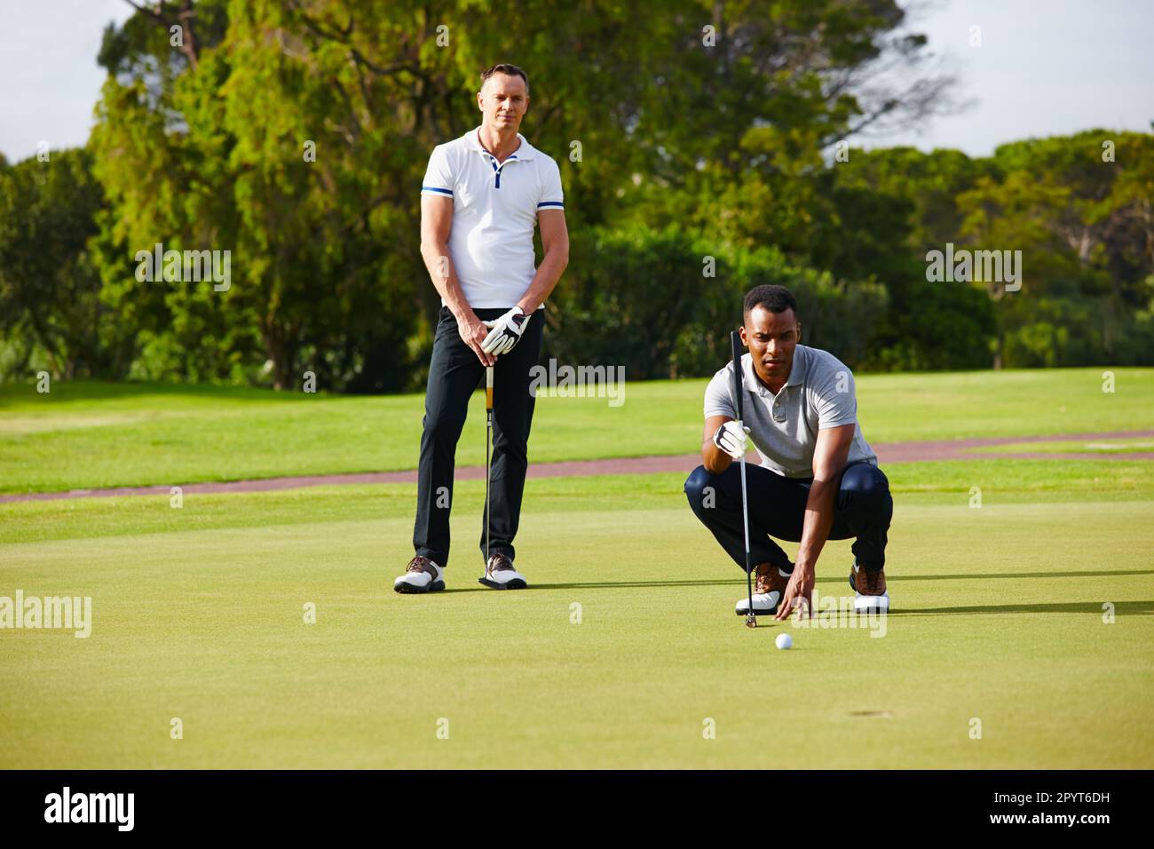 Il golf non è adatto ai deboli di cuore. due golfers che osservano mentre la sfera si avvicina al foro. Foto Stock