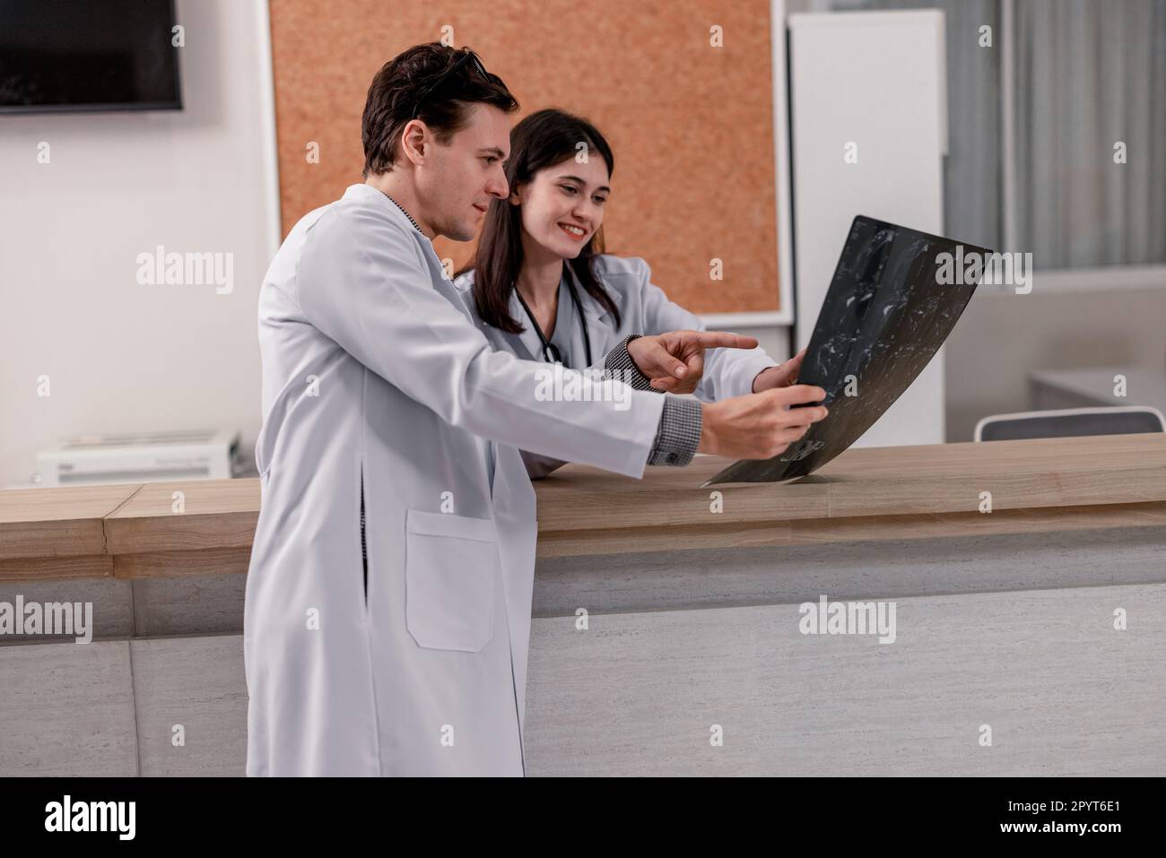 Il medico e il radiologo analizzano le immagini mediche, inclusa la pellicola per RM, per identificare le condizioni del paziente al fine di sviluppare piani di trattamento e farmaci futuri Foto Stock