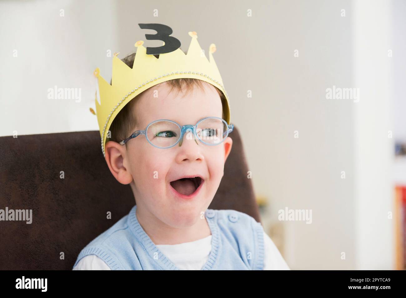 Un ragazzo felice che indossa la corona è sorpreso al suo compleanno, Baviera, Germania Foto Stock
