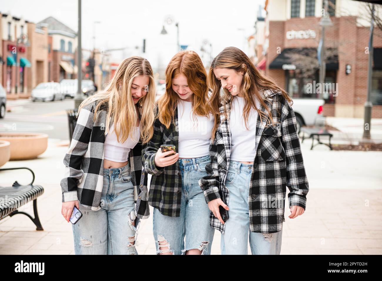 Tre ragazze teen belle che guardano un telefono delle cellule. Foto Stock