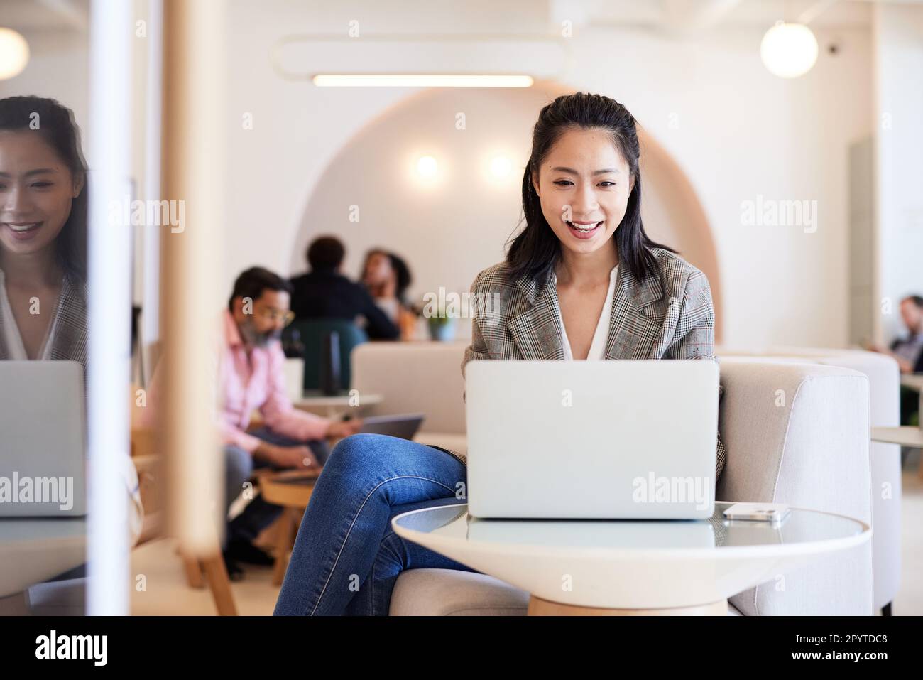 Sorridente imprenditore che lavora su un computer portatile in ufficio Foto Stock