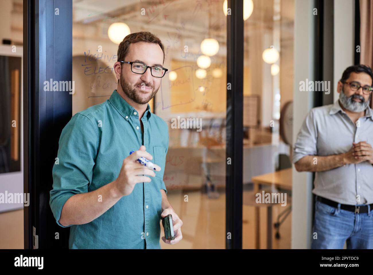 Sorridente imprenditore maschile che indossa occhiali durante la riunione di lavoro Foto Stock