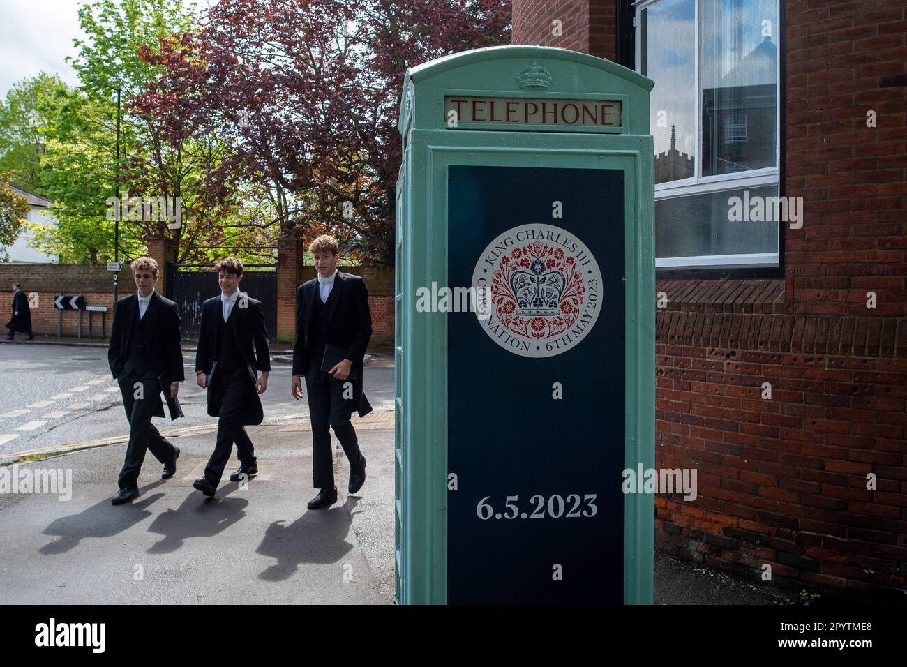 Eton, Windsor, Berkshire, Regno Unito. 5th maggio, 2023. I ragazzi dell'Eton College passano davanti a una cresta dell'incoronazione su una cassetta telefonica che segna l'occasione dell'incoronazione del Re. Il figlio di Re Carlo III, Principe William e Principe Harry, andò a scuola alla famosa scuola pubblica dell'Eton College di Eton, Windsor. Credit: Maureen McLean/Alamy Live News Foto Stock