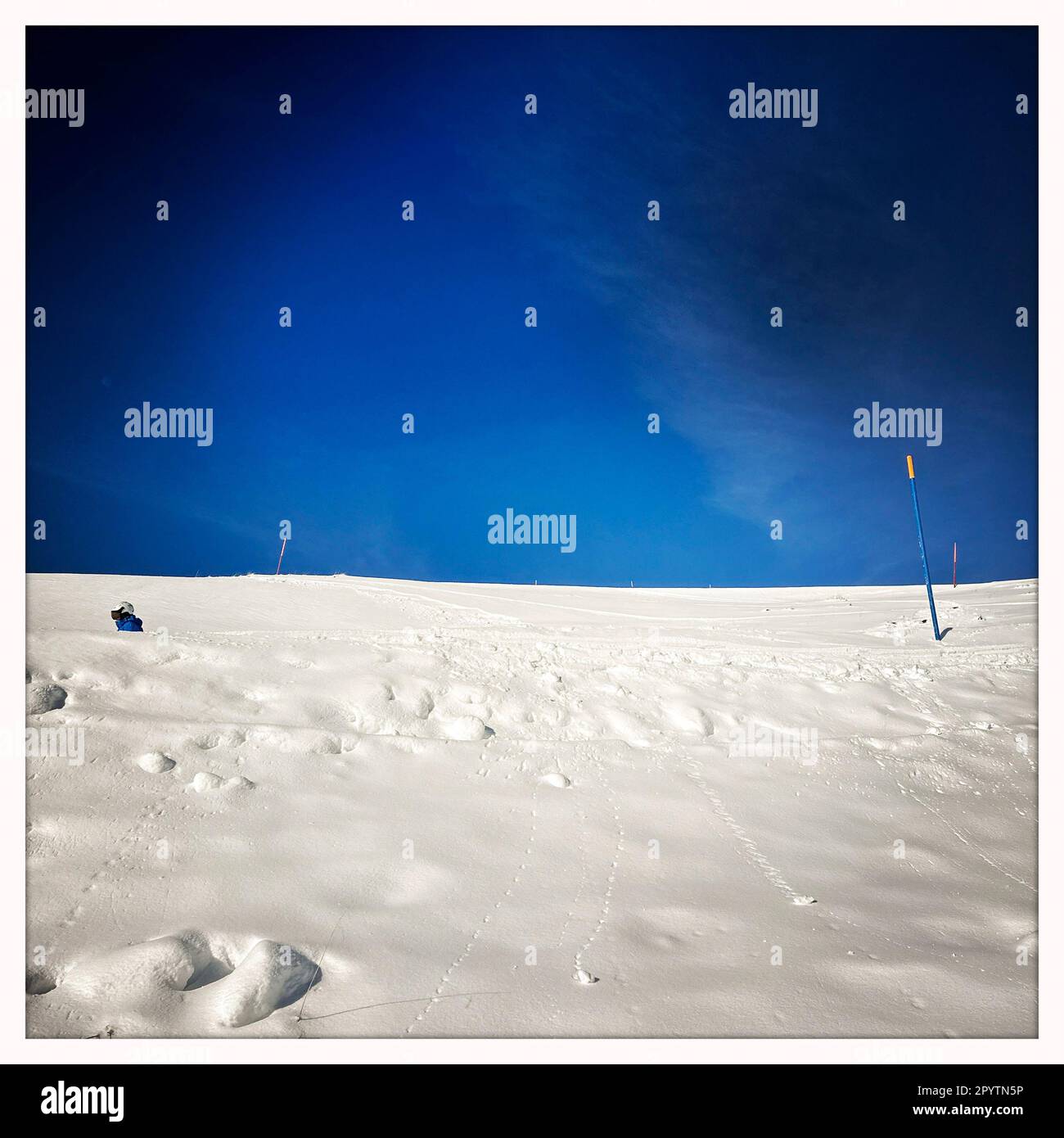 DALLA SERIE ADELBODEN sciatori in discesa su una pista di fronte a un paesaggio invernale intorno a Sillerenbuehl in Adelboden, Oberland Bernese, Canton Berna, Svizzera. La pittoresca cittadina di Adelboden è un idillio svizzero nelle Alpi Bernesi, vette impressionanti, paesaggio invernale unico, popolare area sciistica, pascoli alpini, cascate frettolose, accoglienti case in legno. A causa del cambiamento climatico e di una quantità sempre minore di neve, il classico centro sportivo invernale si sta riorientando e la stagione estiva sta diventando sempre più importante. Foto scattata con iPhone, app Hipstamatic. Foto Stock