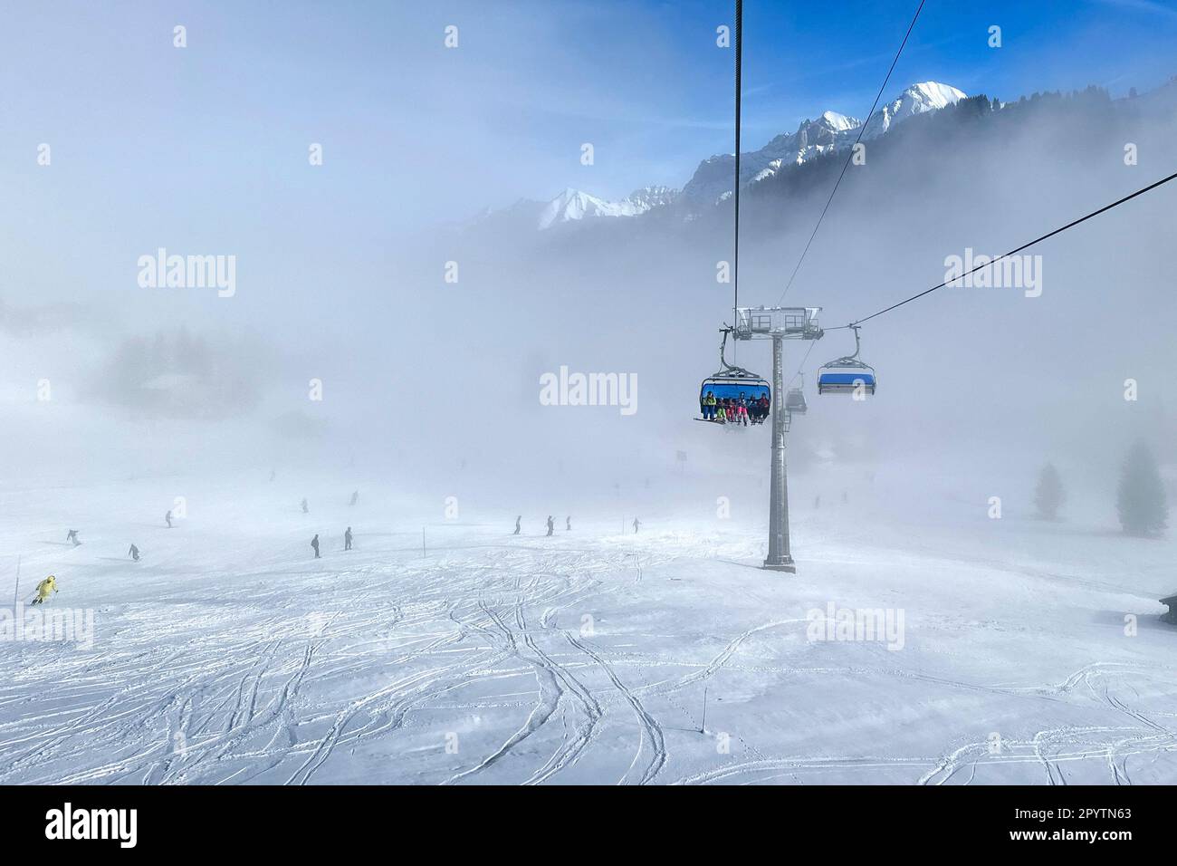 DALLA SERIE ADELBODEN funivia nella neve di fronte al paesaggio invernale a Adelboden, Oberland Bernese, Canton Berna, Svizzera. La pittoresca cittadina di Adelboden è un idillio svizzero nelle Alpi Bernesi, vette impressionanti, paesaggio invernale unico, popolare area sciistica, pascoli alpini, cascate frettolose, accoglienti case in legno. A causa del cambiamento climatico e di una quantità sempre minore di neve, il classico centro sportivo invernale si sta riorientando e la stagione estiva sta diventando sempre più importante Foto Stock