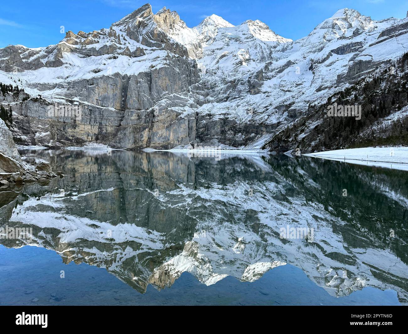 DALLA SERIE DI ADELBODEN paesaggio invernale sul lago Oeschinensee vicino a Kandersteg vicino Adelboden, Oberland Bernese, Canton Berna, Svizzera la pittoresca città di Adelboden è un idillio svizzero nelle Alpi Bernesi, vette impressionanti, paesaggio invernale unico, popolare area sciistica, pascoli alpini, cascate frettolose, accoglienti case in legno. A causa del cambiamento climatico e di una quantità sempre minore di neve, il classico centro sportivo invernale si sta riorientando e la stagione estiva sta diventando sempre più importante. Foto Stock