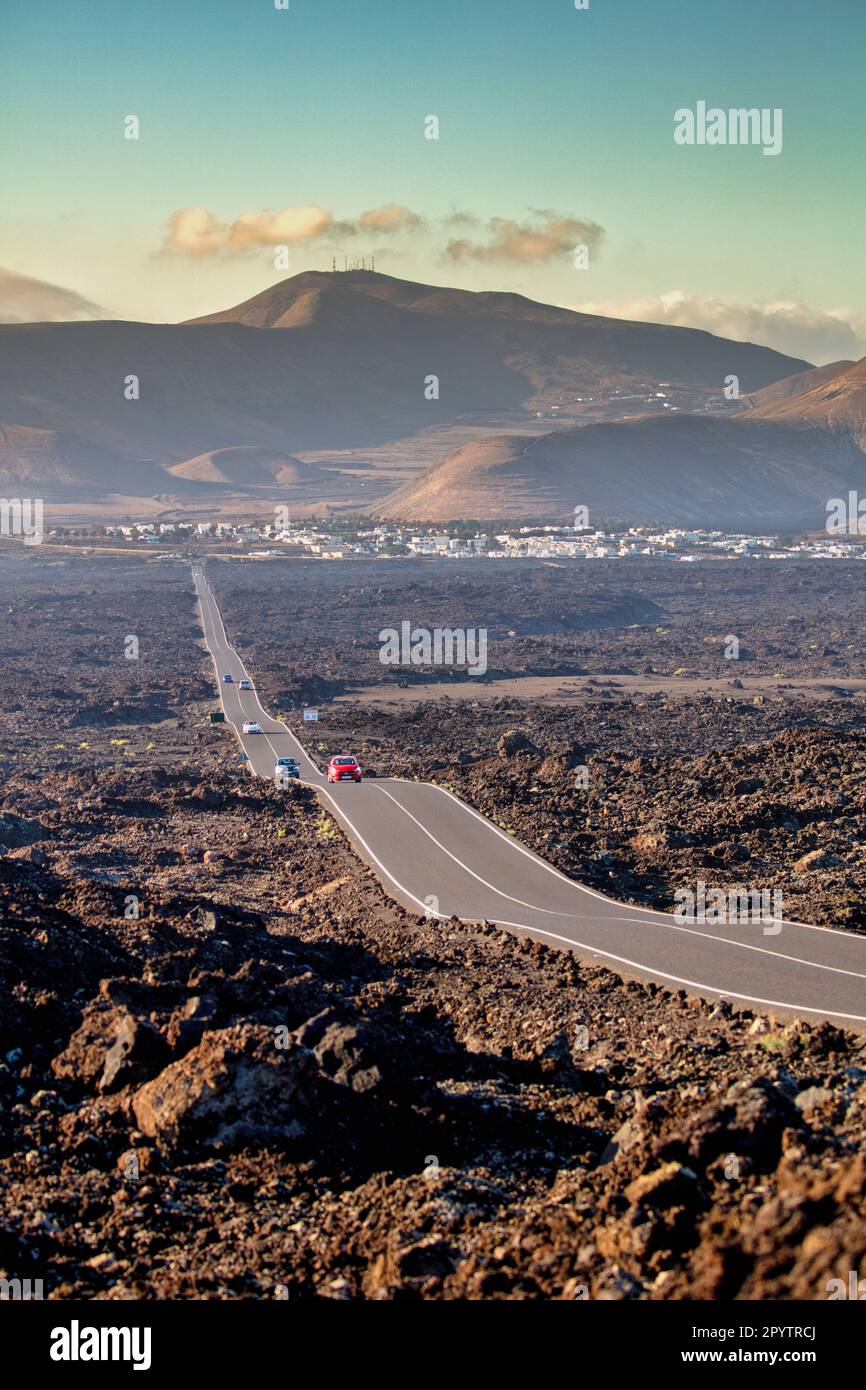 Spagna, Isole Canarie, Lanzarote, Parco Nazionale di Timanfaya, Montagnas del Fuego, Fire Mountains, cratere vulcanico paesaggio. Strada per parcheggiare. Backgr Foto Stock