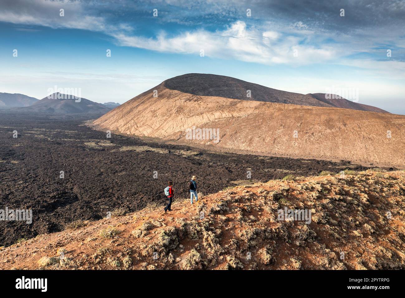 Spagna, Isole Canarie, Lanzarote, Parco Nazionale di Timanfaya, Montagnas del Fuego, Fire Mountains, cratere vulcanico paesaggio. Alba. Escursionisti su C Foto Stock