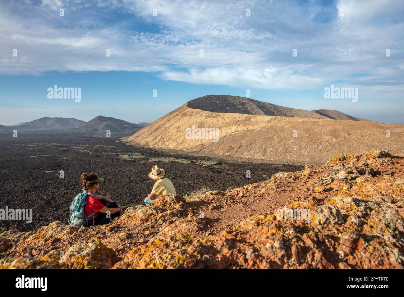 Spagna, Isole Canarie, Lanzarote, Parco Nazionale di Timanfaya, Montagnas del Fuego, Fire Mountains, cratere vulcanico paesaggio. Alba. Escursionisti su C Foto Stock