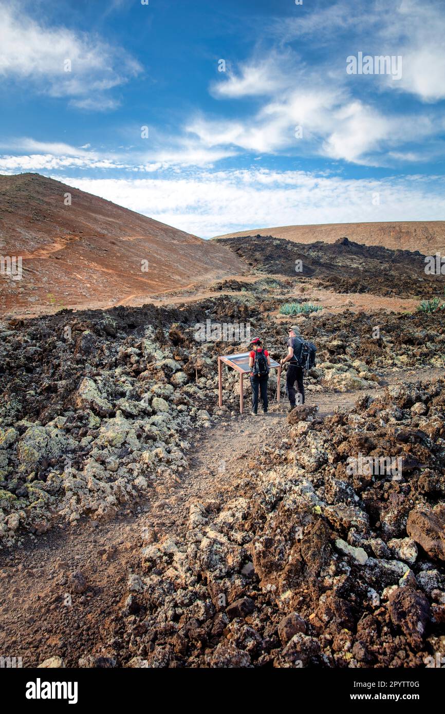 Spagna, Isole Canarie, Lanzarote, Parco Nazionale di Timanfaya, Montagnas del Fuego, Fire Mountains, cratere vulcanico paesaggio. Alba. Escursionisti vicino Foto Stock