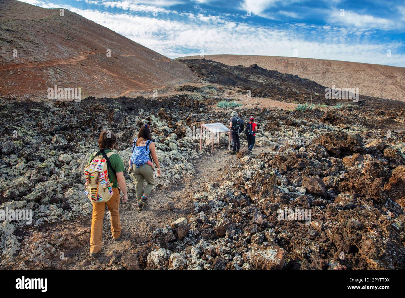 Spagna, Isole Canarie, Lanzarote, Parco Nazionale di Timanfaya, Montagnas del Fuego, Fire Mountains, cratere vulcanico paesaggio. Alba. Escursionisti vicino Foto Stock