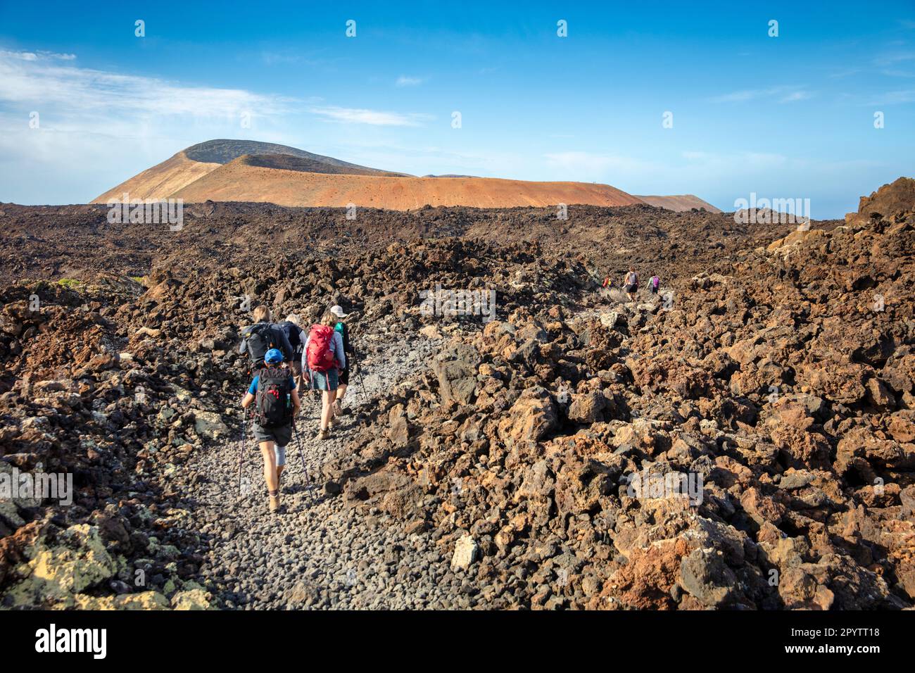 Spagna, Isole Canarie, Lanzarote, Parco Nazionale di Timanfaya, Montagnas del Fuego, Fire Mountains, cratere vulcanico paesaggio. Alba. Escursionisti cros Foto Stock