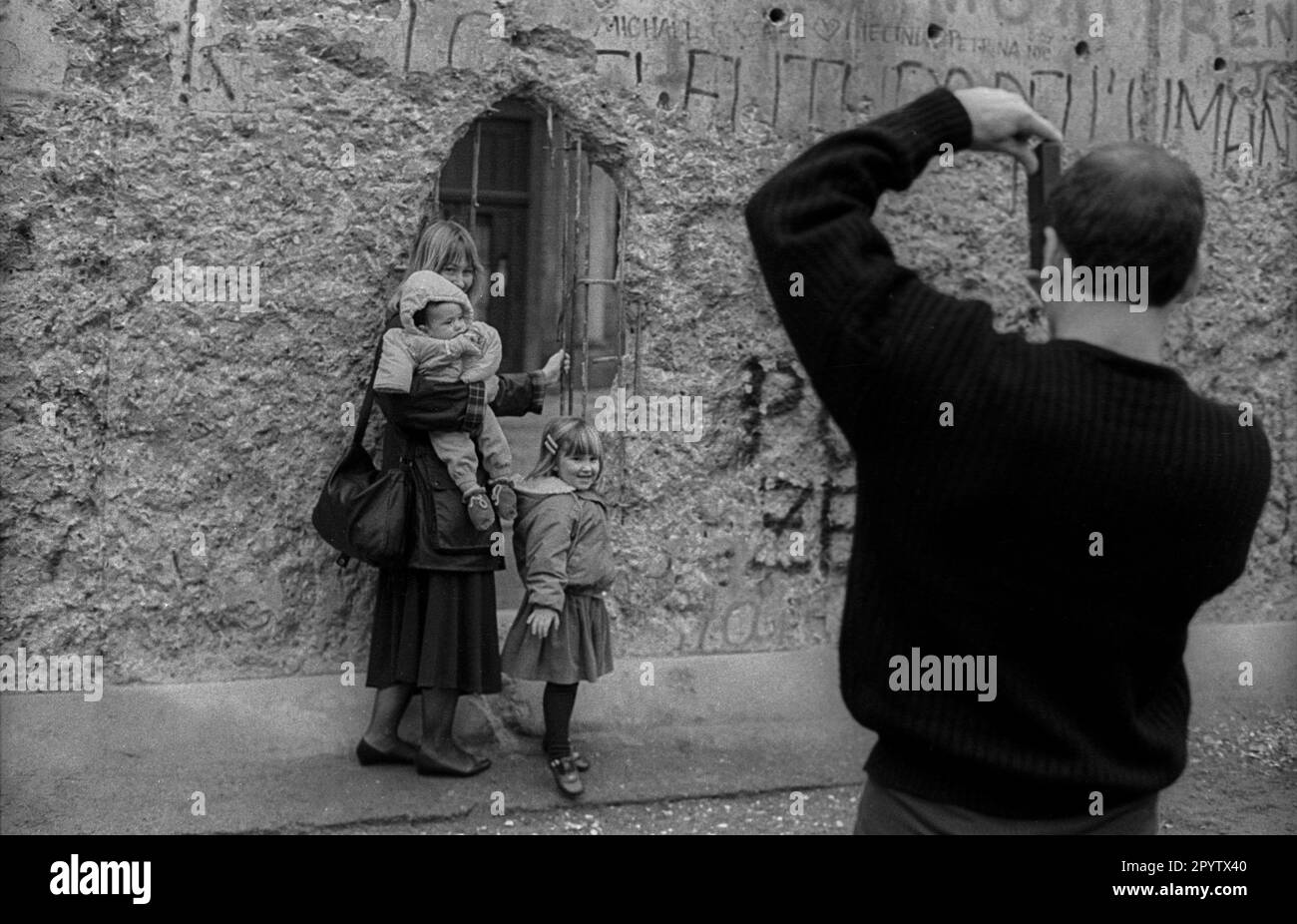 GDR, Berlino, 11,1.1990, i turisti scattano foto di se stessi al Muro della porta di Brandeburgo, [traduzione automatica] Foto Stock
