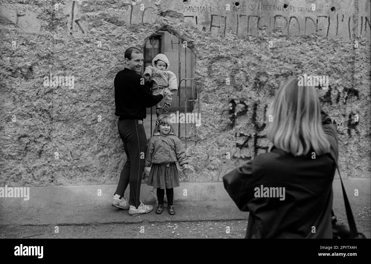 GDR, Berlino, 11,1.1990, i turisti scattano foto di se stessi al Muro della porta di Brandeburgo, [traduzione automatica] Foto Stock