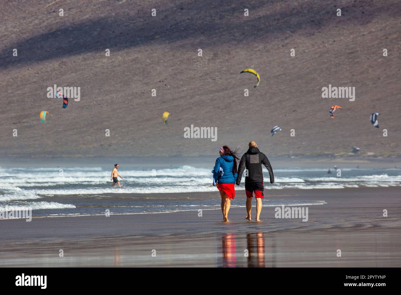 Spagna, Isole Canarie, Lanzarote. Playa de Famara. Kite surfisti. Escursioni in coppia. Foto Stock