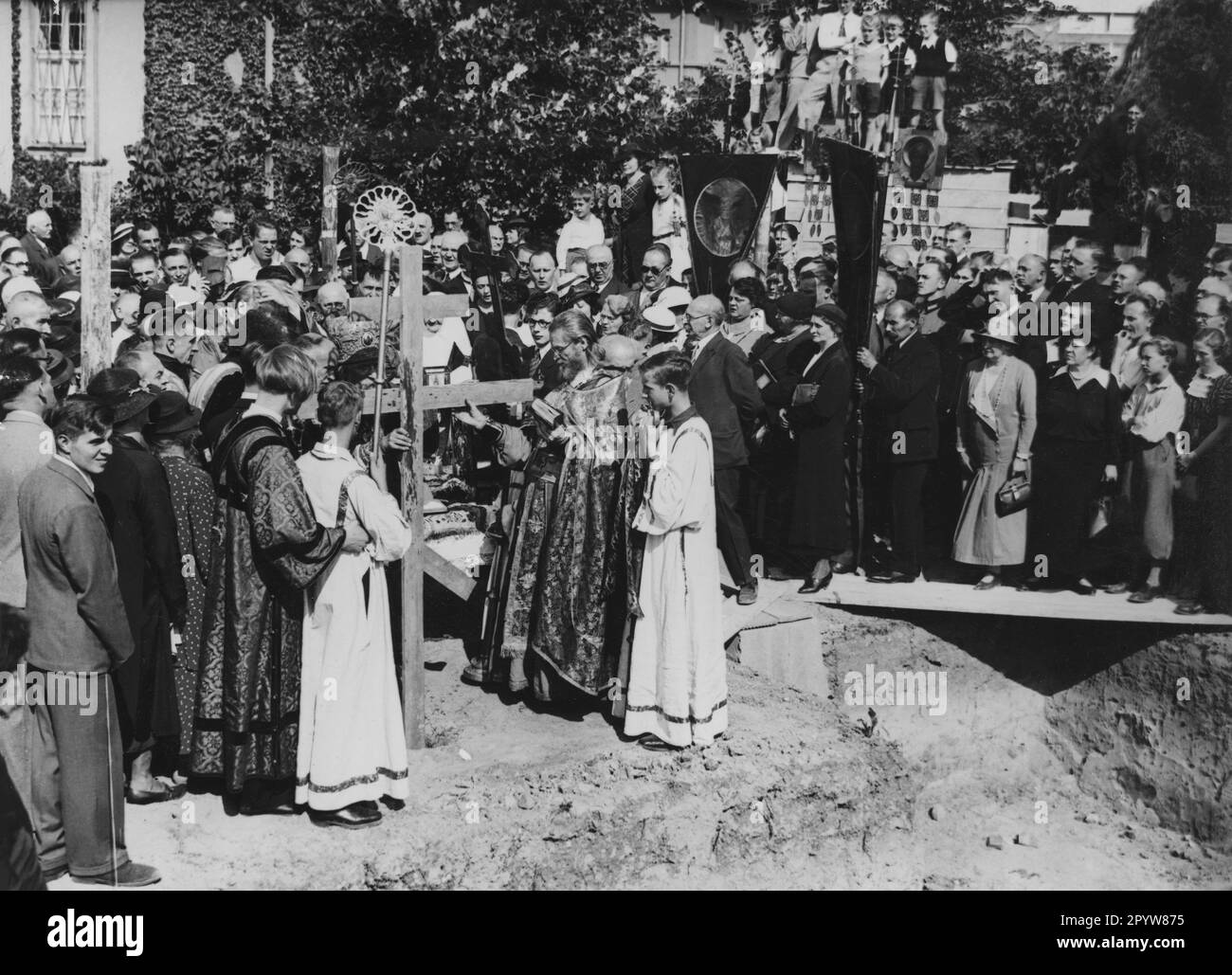 Posa della prima pietra della Chiesa Ortodossa Russa a Honenzollernplatz a Berlino. Il vescovo Tikhon (Tyhon) (a destra) benedice la croce che è sepolta nel cantiere. [traduzione automatica] Foto Stock