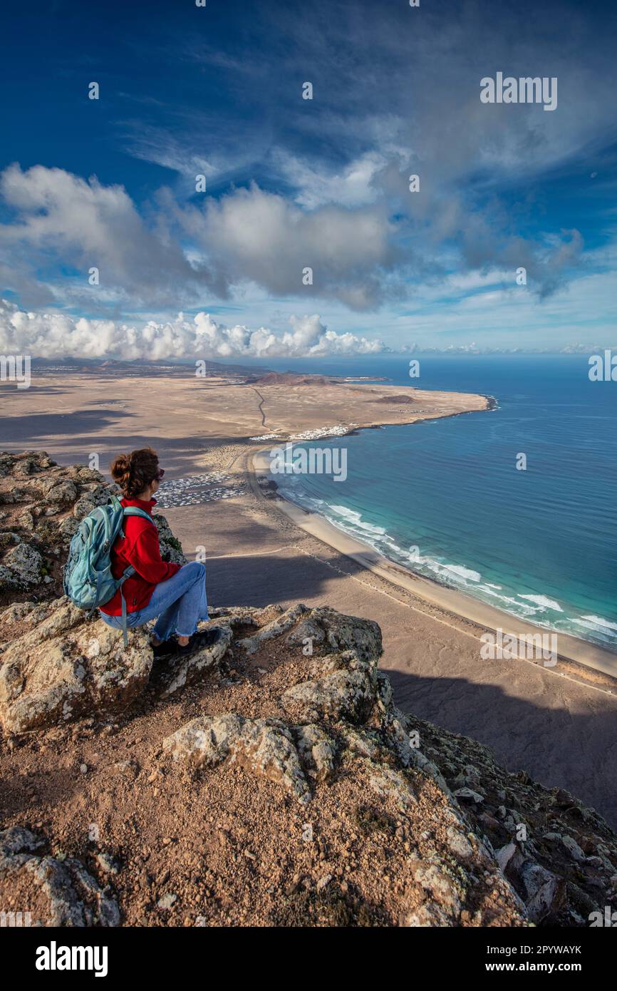 Spagna, Isole Canarie, Lanzarote, Haria. Ermita Las Nieves. Punto di vista, punto di osservazione. Vista sul villaggio Caleta de Famara. Antenna. Escursionista. Versioni del modello Foto Stock