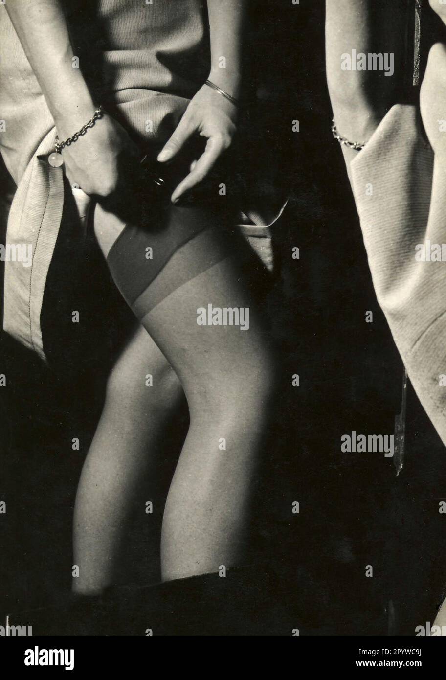 La donna fissa le calze alla cintura di garter. [traduzione automatica] Foto Stock