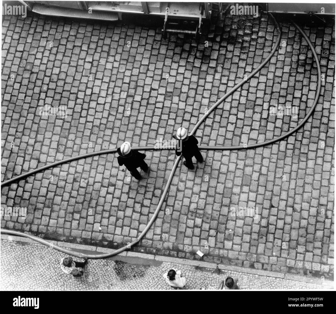 Incidenti e sfortuna: Vigili del fuoco. Vigili del fuoco in azione in un incendio di capriate sul tetto a Berlino-Neukölln. Street scene dall'alto, in bianco e nero. Foto, 1991. Foto Stock