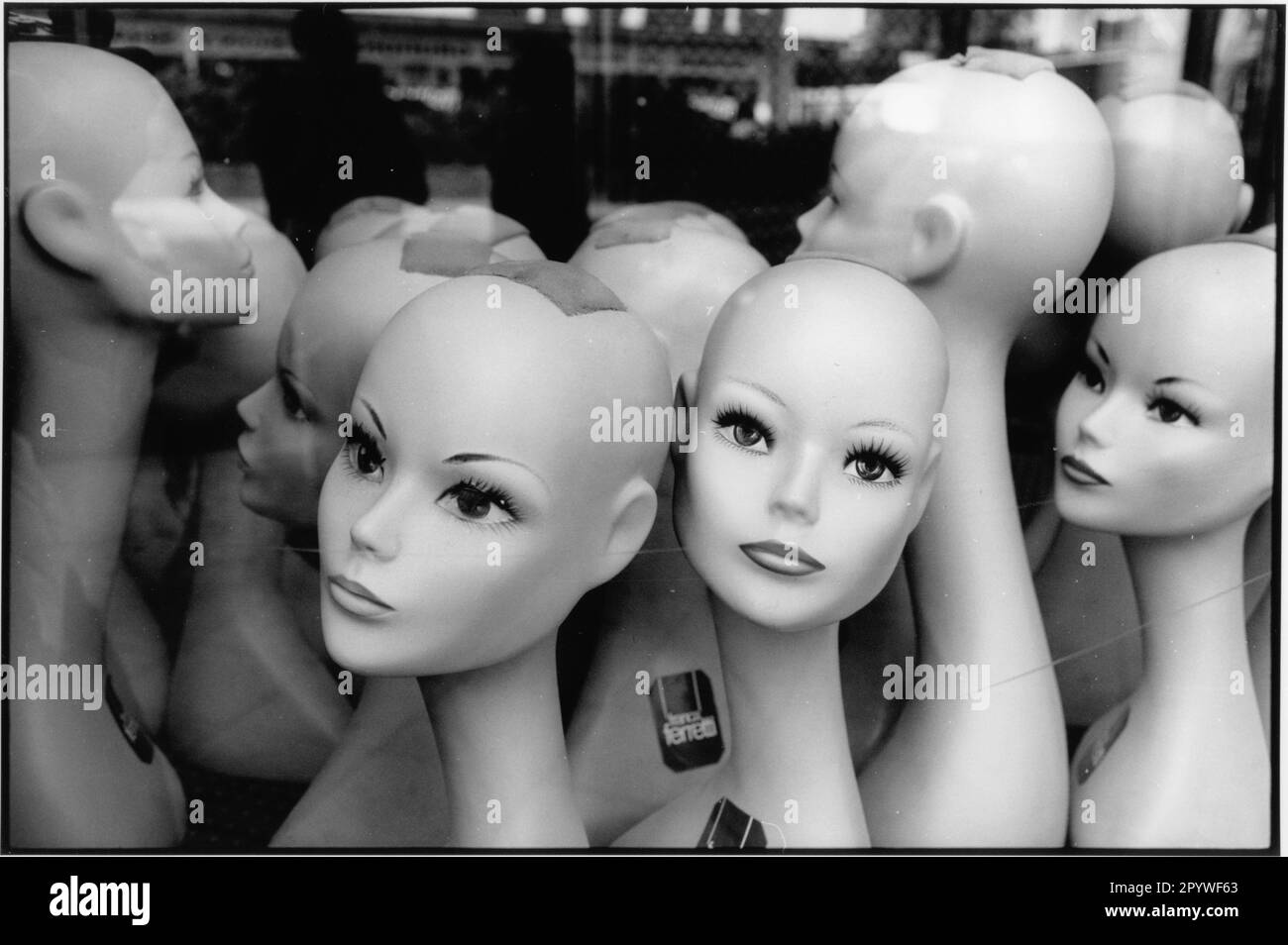 Berlino-Neukölln, Karl-Marx-Strasse. Commercio, vetrine. Teste di manichini in un negozio di parrucche. Bianco e nero. Foto, 1992. Foto Stock