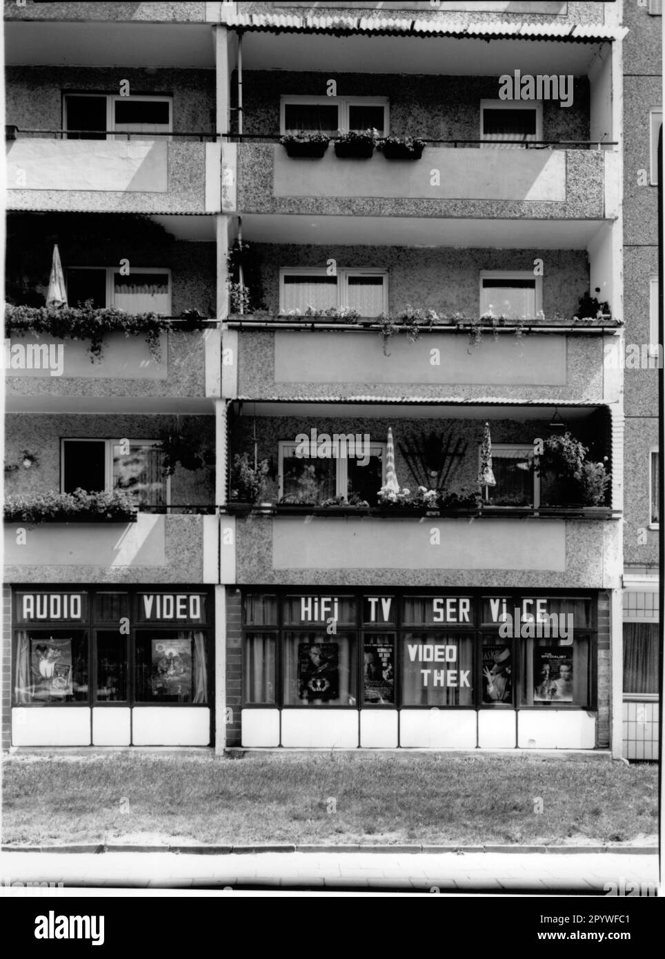 Germania orientale, Strausberg. ''Casa Sweet Home''. Videoteca nell'edificio prefabbricato, sopra i balconi degli appartamenti. Street scene, bianco e nero. Foto, 1995.' Foto Stock