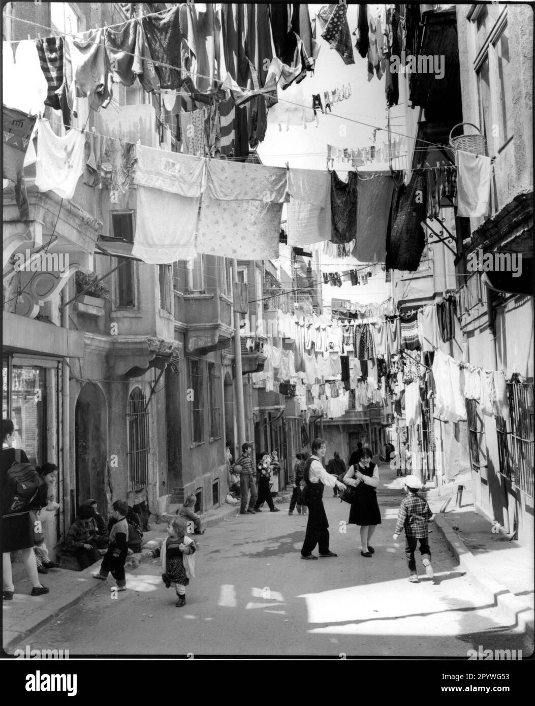 Istanbul (Turchia), quartiere di Beyoglu. ''giorno di lavaggio'' Bambini sulla strada, lavanderia pende sul vicolo. Street scene, bianco e nero. Foto, 1994.' Foto Stock