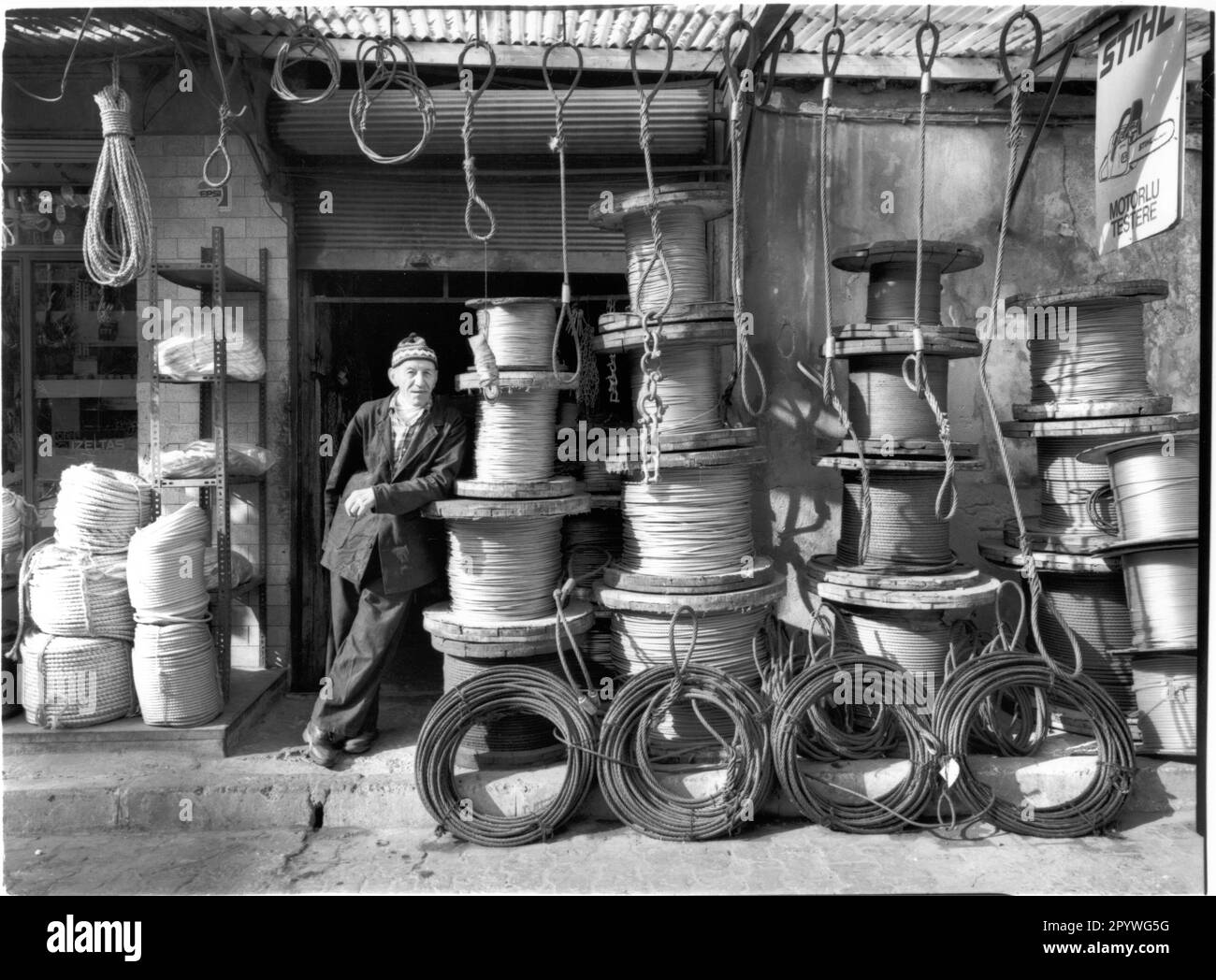 Istanbul (Turchia), distretto di Karakoy (Galata). Macchina per funi con pulegge davanti al suo negozio. Street scene, bianco e nero. Foto, 1994. Foto Stock
