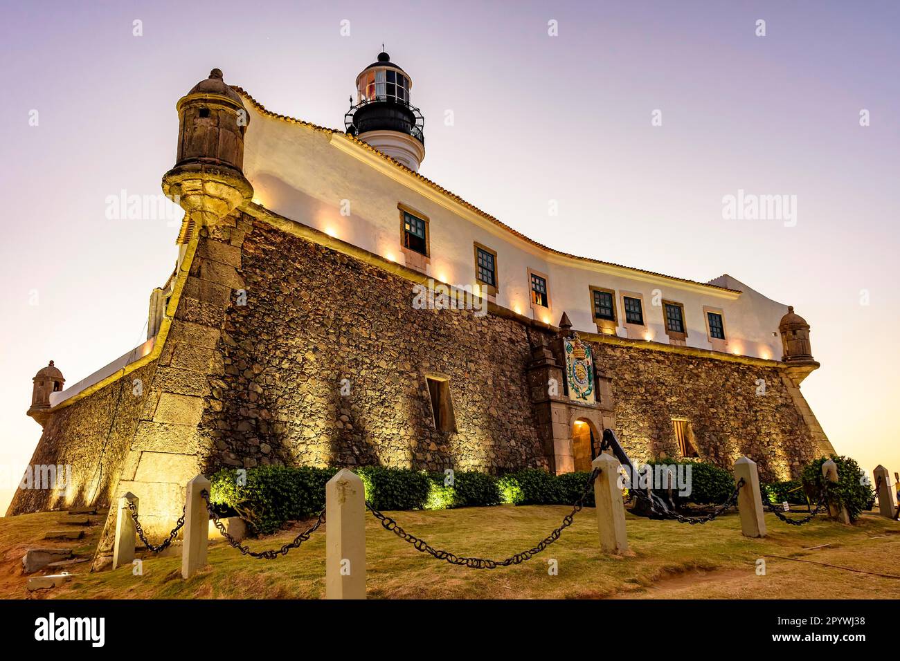 Facciata del vecchio e storico forte e faro a barra durante il tramonto nella città di Salvador, Bahia, Brasile Foto Stock