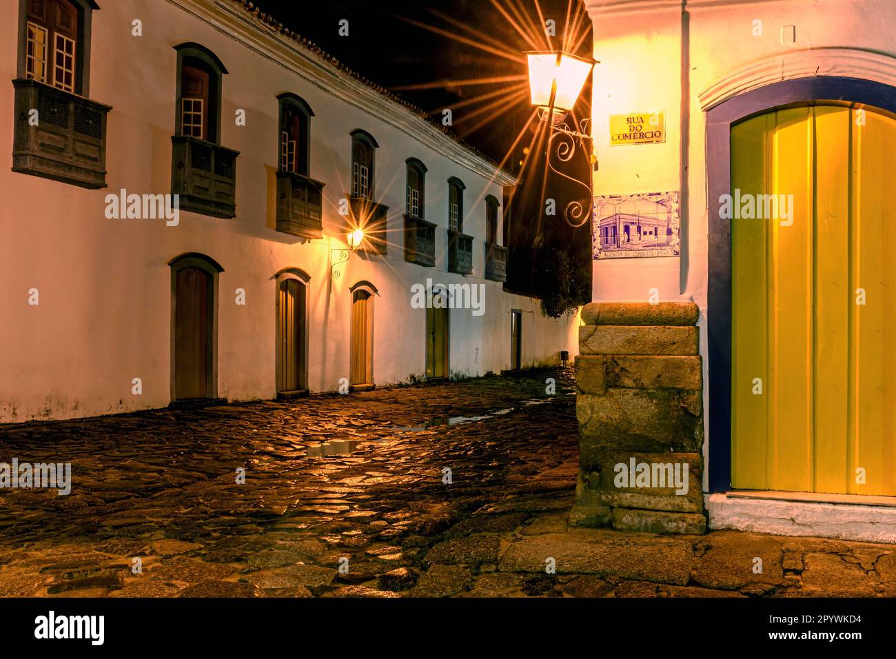 Strada acciottolata e riflessioni in pozzanghere nella storica città di Paraty durante una notte di estate piovosa, il Brasile Foto Stock