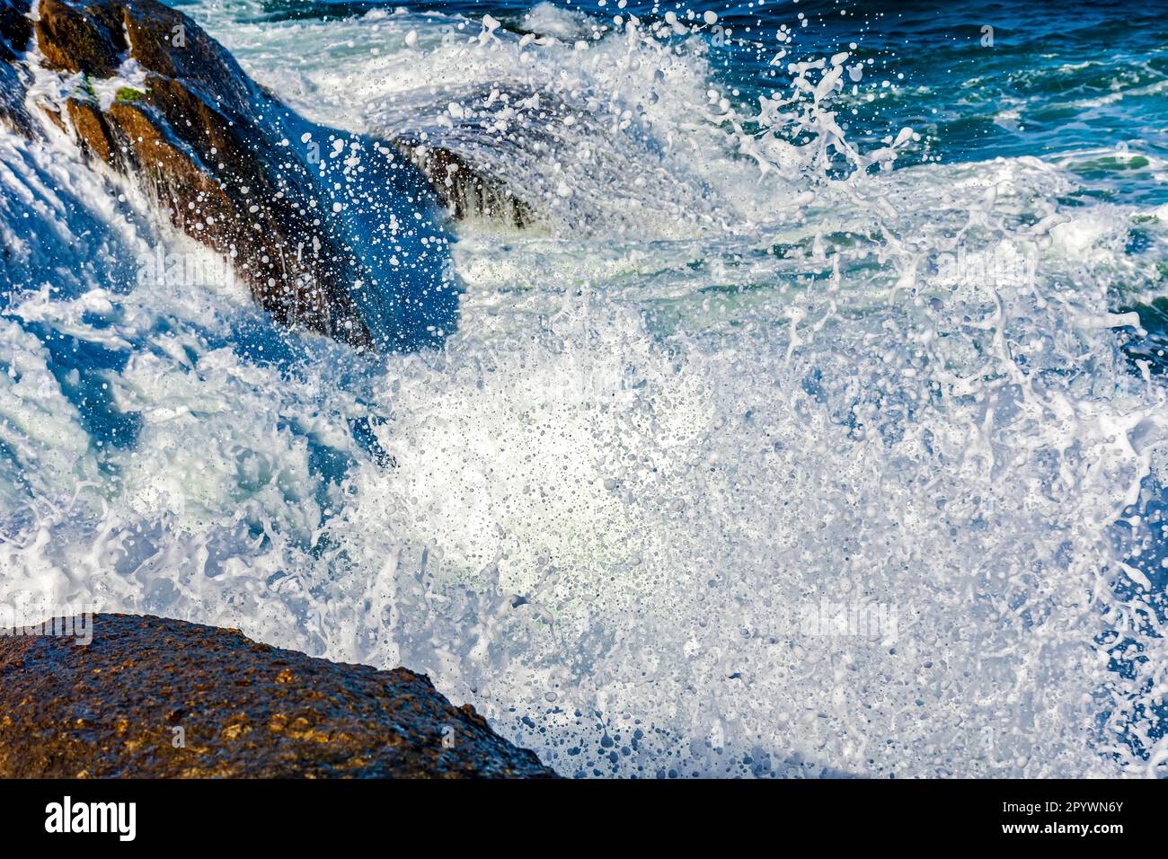 Urto d'onda contro le rocce con spruzzi d'acqua di mare in aria, Brasile Foto Stock